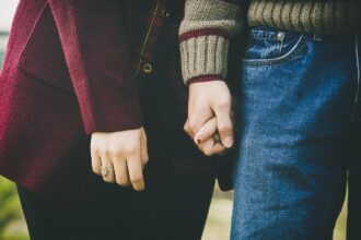 Người phụ nữ ngồi trên bãi biển ngắm hoàng hôn, thể hiện sự chiêm nghiệm về ranh giới trong tình yêu lâu dài.