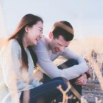 Người phụ nữ ngồi trầm ngâm bên cửa sổ, tay ôm ly trà ấm, ánh mắt xa xăm, tượng trưng cho nỗi băn khoăn vì sao hay ghen dù người yêu không sai.