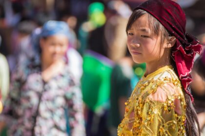 Người phụ nữ trẻ ngồi buồn bã nhìn ra cửa sổ, ánh trăng mờ chiếu qua, khuôn mặt cô ấy đượm buồn và suy tư, như đang đối mặt với những dấu hiệu nên buông tay.